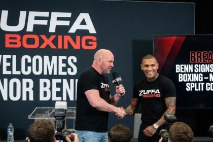 Boxer Conor Benn raising his gloves confidently inside the boxing ring.