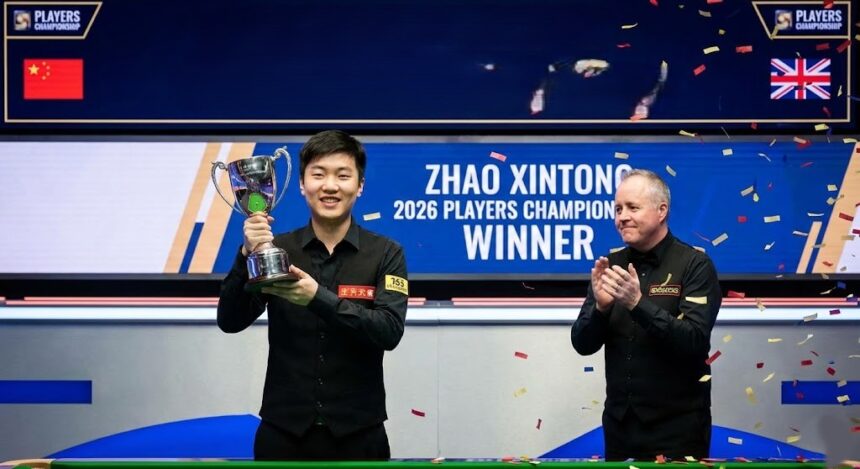 Snooker champion Zhao Xintong intensely lining up a shot on the billiard table during a professional match.