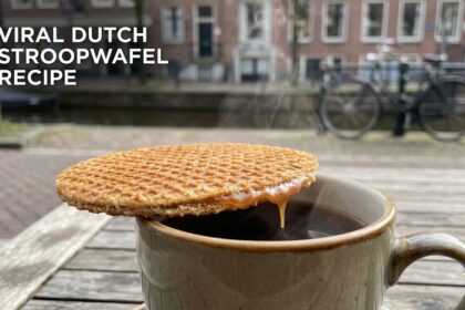 A fresh, golden-brown Dutch stroopwafel being pulled apart to reveal the gooey caramel center.