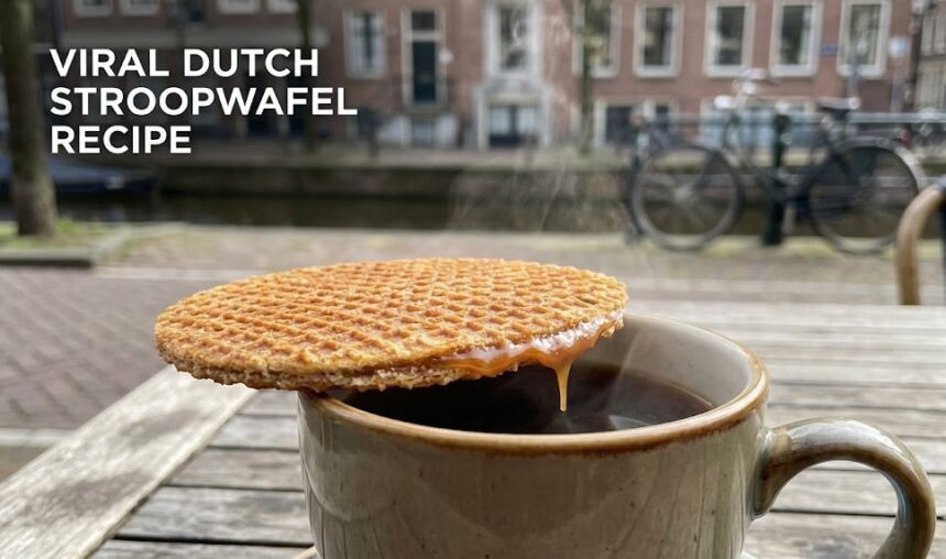 A fresh, golden-brown Dutch stroopwafel being pulled apart to reveal the gooey caramel center.